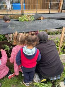 Niños y niñas mirando los canteros de la huerta con el tallerista