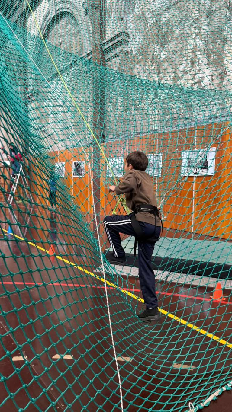 Niño trepando una red durante la visita a La Muralla