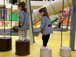 Dos niñas caminando en equilibrio sobre postes